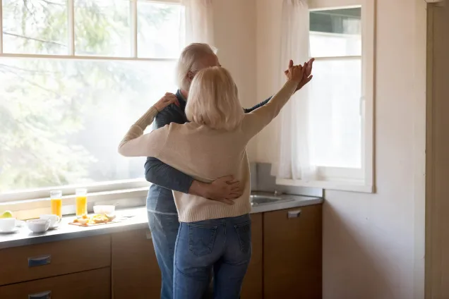 whitehaired couple dancing in kitchen