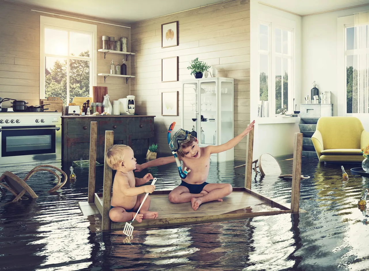 two children on table raft in flooded kitchen